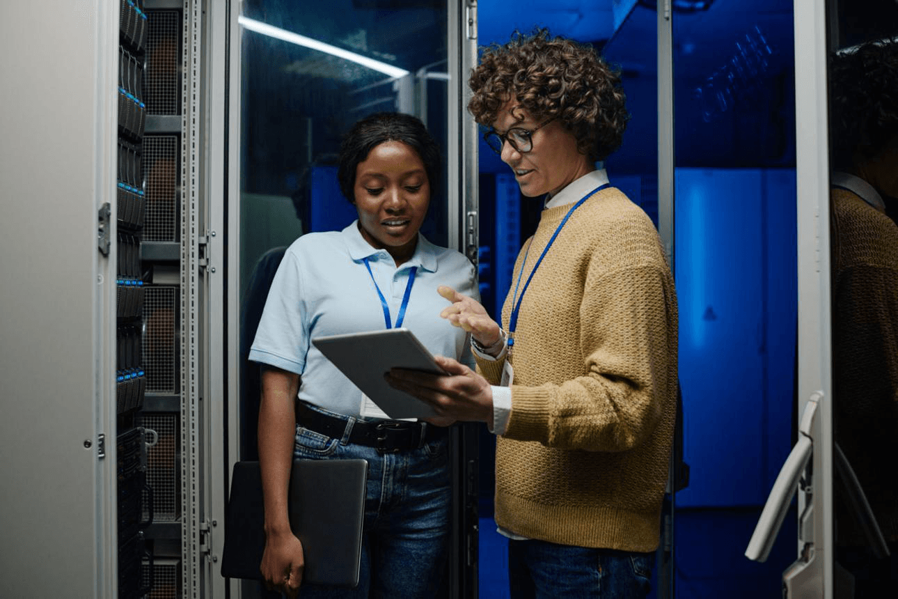 Two professionals reviewing infrastructure in a server room